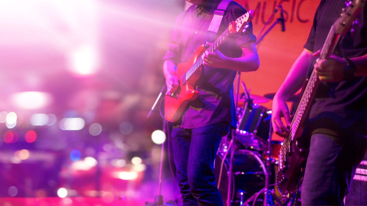 Guitarist and colorful lighting on a stage, soft focus